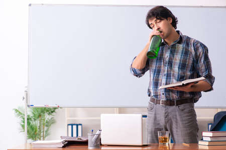 Male teacher drinking in the classroomの写真素材