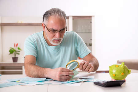 White bearded old man in budget planning conceptの写真素材