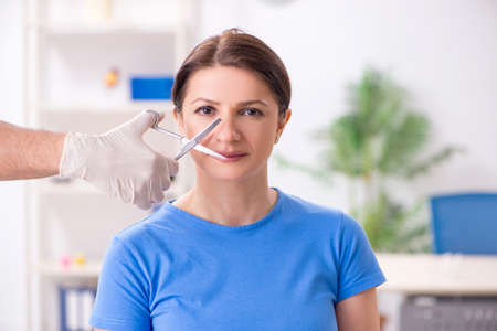 Woman visiting male doctor for plastic surgery