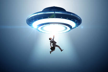 Flying saucer abducting young businessmanの写真素材