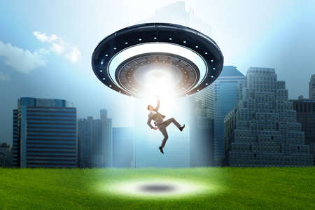 Flying saucer abducting young businessmanの写真素材