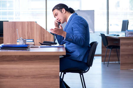 Young handsome businessman sitting in the officeの写真素材