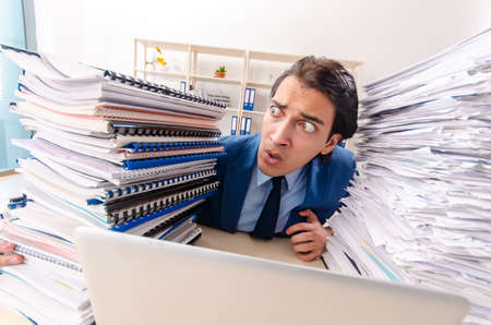 Young handsome businessman unhappy with excessive work