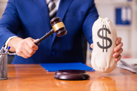 Young male judge sitting in courtroomの写真素材