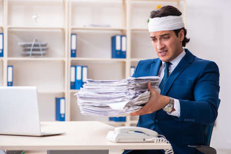 Head injured male employee working in the officeの写真素材