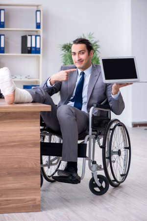 Male employee in wheel-chair in the officeの写真素材