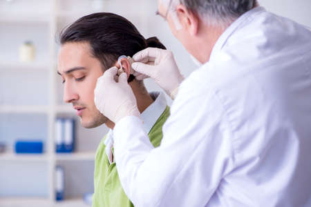 Male patient with hearing problem visiting doctor otorhinolaryngの写真素材