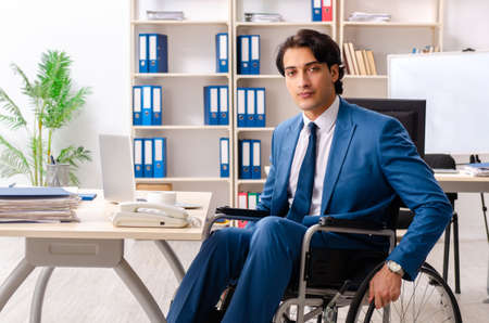 Male employee in wheelchair working at the officeの写真素材