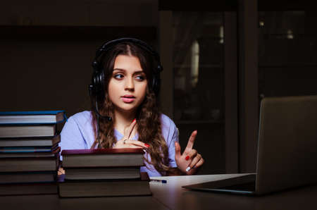 Young female student preparing for exams late at home