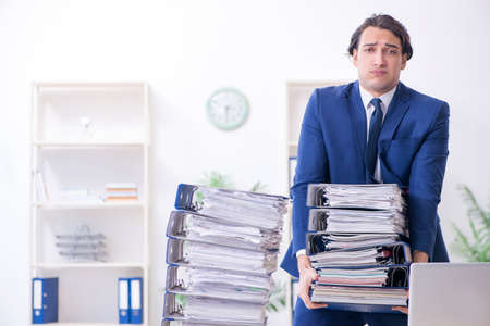 Young male employee unhappy with excessive workの写真素材