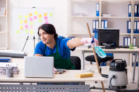 Male handsome professional cleaner working in the office