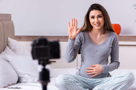 Pregnant woman recording video for her blogの写真素材