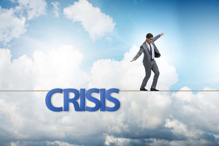 Crisis concept with businessman walking on tight rope