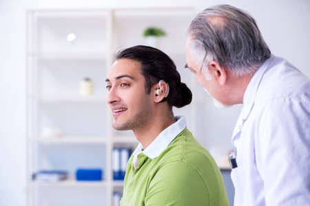 Male patient with hearing problem visiting doctor otorhinolaryngの写真素材