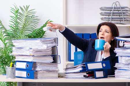Middle-aged businesswoman unhappy with excessive workの写真素材
