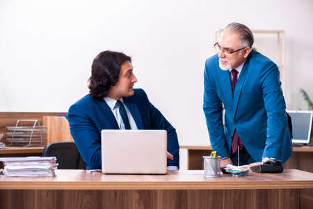 Young and old employees working together in the officeの写真素材