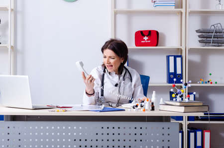 Middle-aged female doctor in telemedicine conceptの写真素材