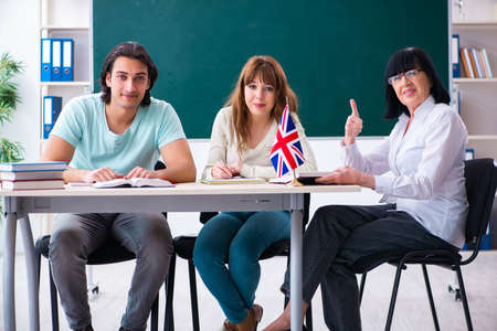 Old female english teacher and students in the classroomの写真素材