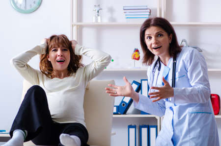 Young pregnant woman visiting experienced doctor gynecologistの写真素材