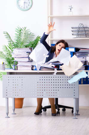 Middle-aged businesswoman unhappy with excessive workの写真素材