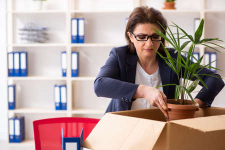 Middle-aged female employee being fired from her workの写真素材