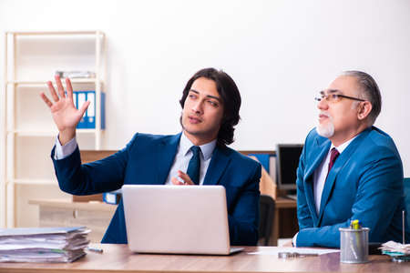 Young and old employees working together in the officeの写真素材