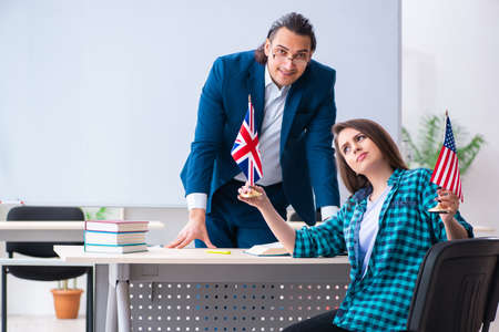 Male english teacher and female student in the classroomの写真素材