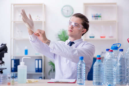 Young male chemist experimenting in labの写真素材