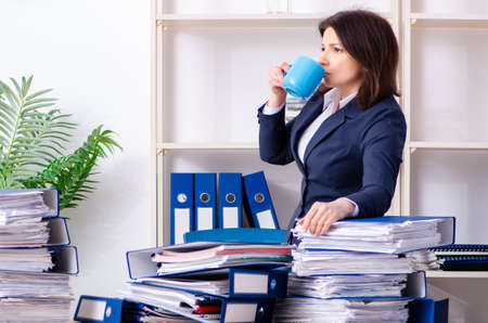 Middle-aged businesswoman unhappy with excessive workの写真素材