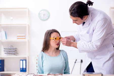 Young woman visiting male doctor oculistの写真素材