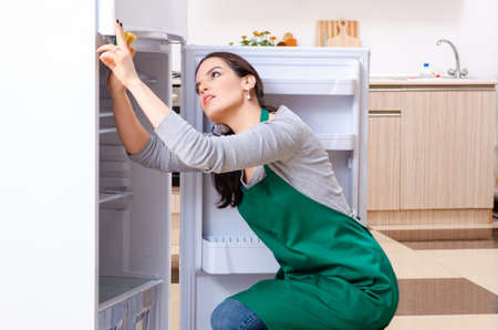 Young woman cleaning fridge in hygiene conceptの写真素材