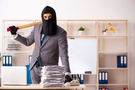 Male gangster stealing information from the officeの写真素材