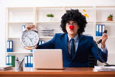 Young clown businessman working in the officeの写真素材