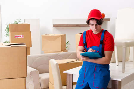 Young male contractor with boxes working indoors
