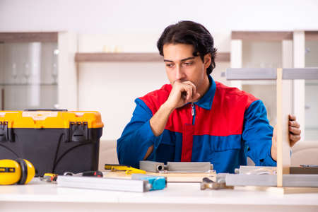 Young contractor repairing furniture at homeの写真素材