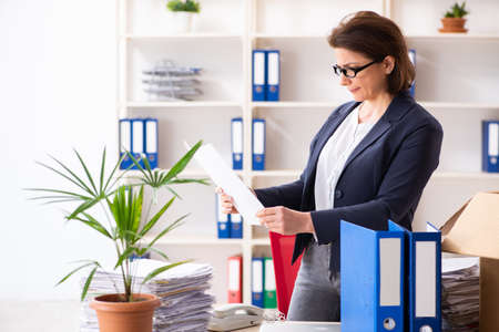 Middle-aged female employee being fired from her workの写真素材