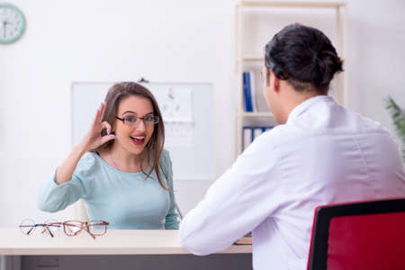 Young woman visiting male doctor oculistの写真素材