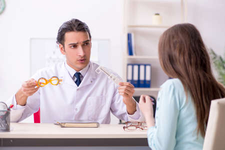 Young woman visiting male doctor oculistの写真素材