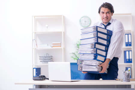 Young male employee unhappy with excessive workの写真素材