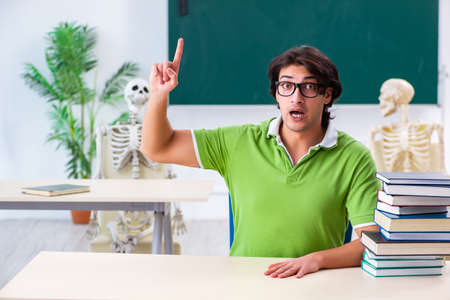 Funny male student in the classroom with skeletonの写真素材