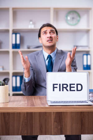 Young male employee being fired from his workの写真素材