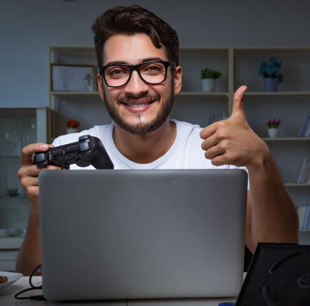 Young man playing games long hours late in the office