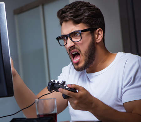 Young man playing games long hours late in the office