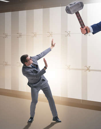 Bad angry boss threatening employee with hammer