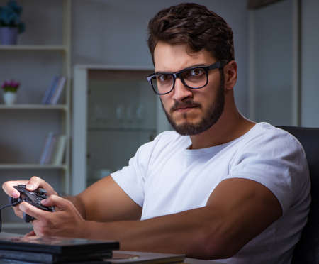 Young man playing games long hours late in the office