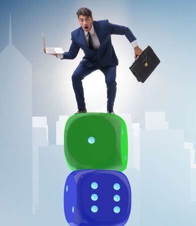 Businessman balancing on top of dice stack in uncertainty conceptの写真素材