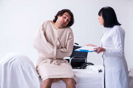 Old female psychiatrist visiting young male patientの写真素材