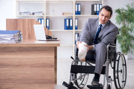 Male employee in wheel-chair in the officeの写真素材