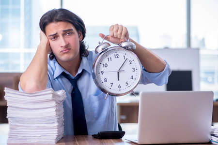 Young employee unhappy with excessive workの写真素材