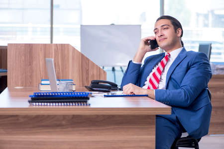 Young handsome businessman sitting in the officeの写真素材